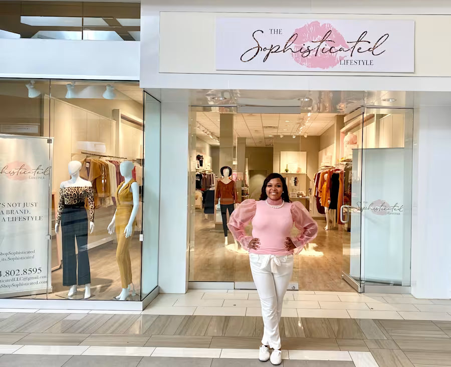 Pennie Bailey standing in front of her first woman's clothing  boutique store named 'The Sophisticated Lifestyle Boutique, in Ann Arbor Michigan.