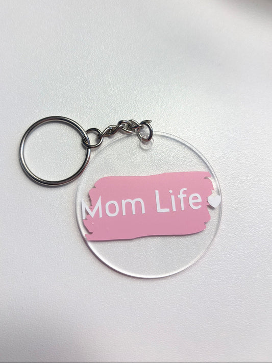 Clear acrylic keychain with pink label reading 'Mom Life' on a white background offered at Pennie's Little Keepsakes . Michigan Made